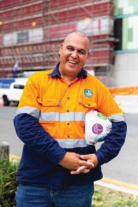 Logan Legend Justin Geange is wearing a high vis shirt and has a hard hat under his arm.