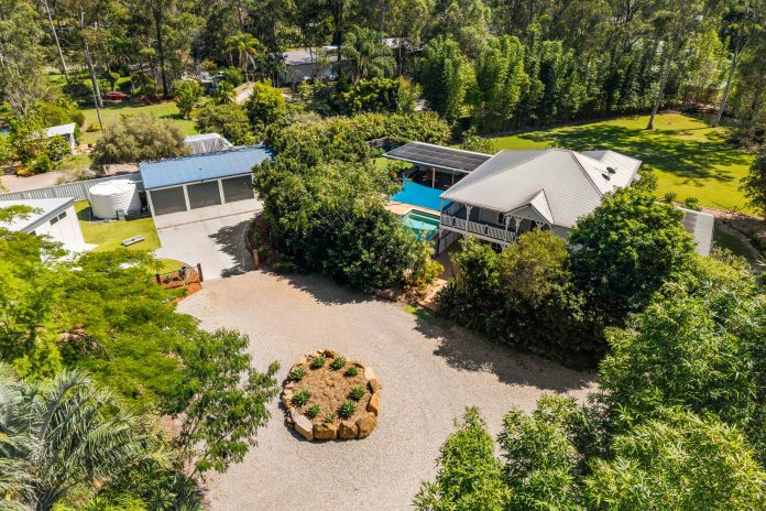 House with driveway, trees and shed.
